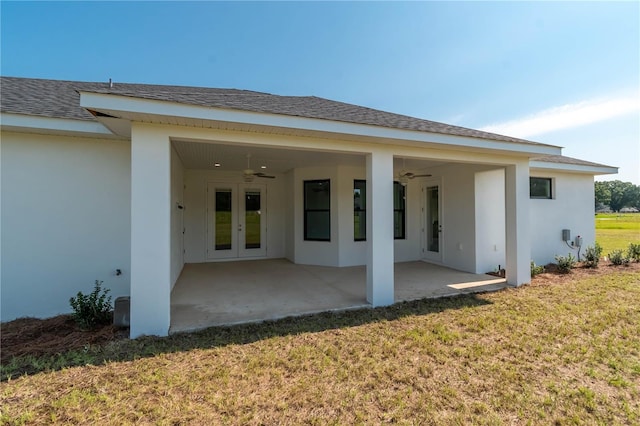 rear view of house with ceiling fan, a lawn, and a patio area