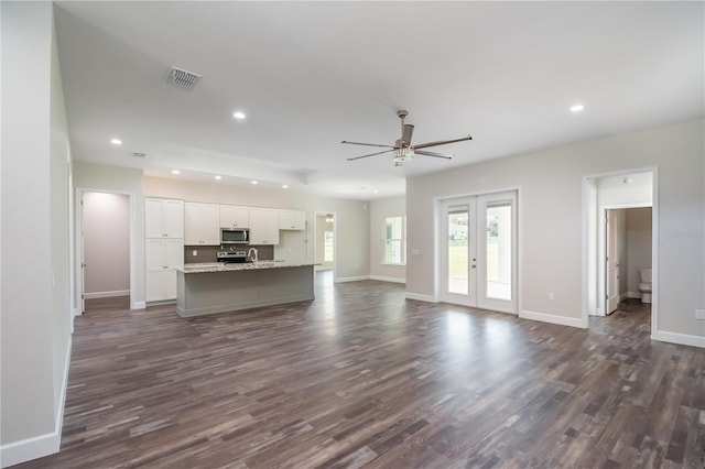 unfurnished living room featuring french doors, dark hardwood / wood-style floors, and ceiling fan