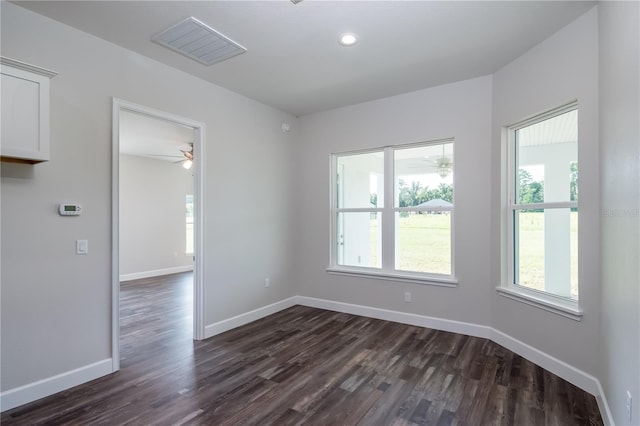 unfurnished room featuring ceiling fan, a healthy amount of sunlight, and dark hardwood / wood-style floors