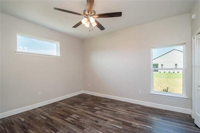 empty room featuring dark hardwood / wood-style floors, a healthy amount of sunlight, and ceiling fan