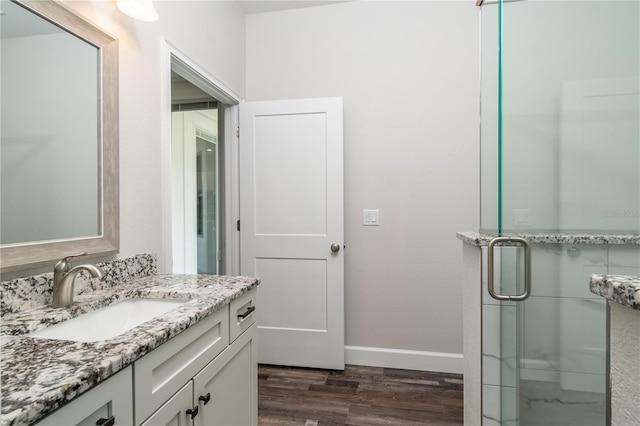 bathroom featuring vanity, a shower with shower door, and hardwood / wood-style flooring