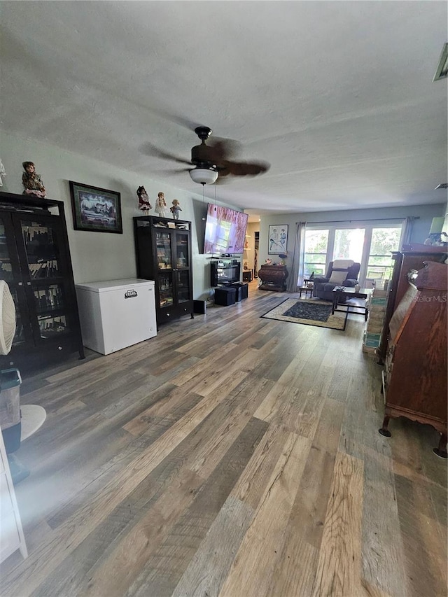 living room featuring hardwood / wood-style floors and ceiling fan