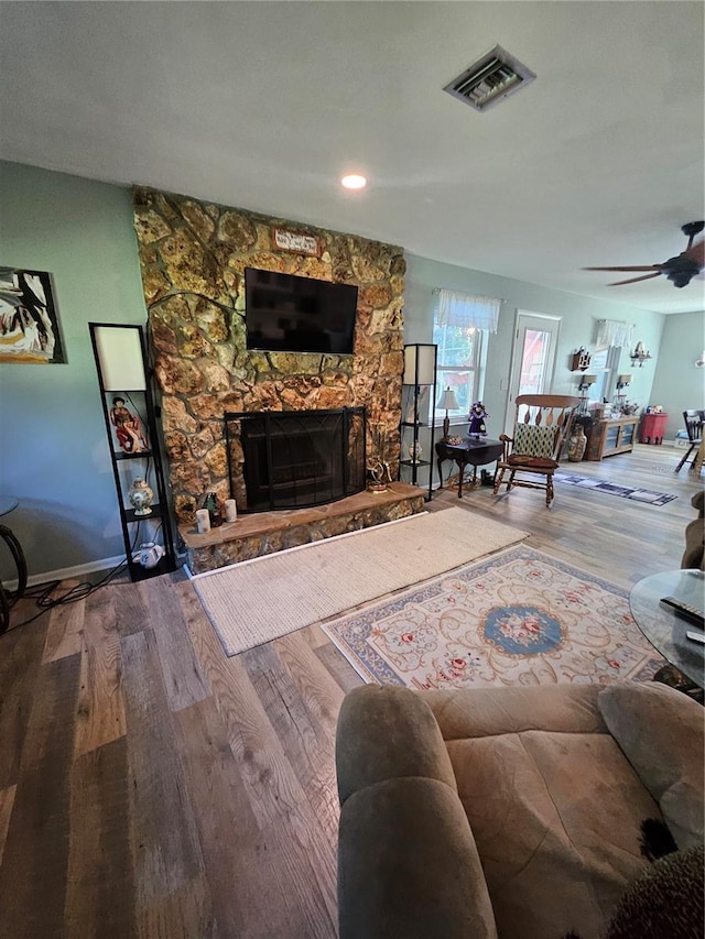 unfurnished living room featuring a fireplace, ceiling fan, and wood-type flooring