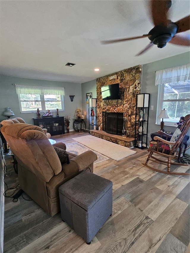 living room with wood-type flooring, a fireplace, and ceiling fan