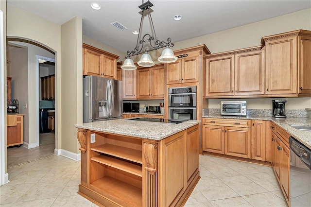 kitchen with hanging light fixtures, stainless steel appliances, a center island, light tile patterned floors, and light stone counters