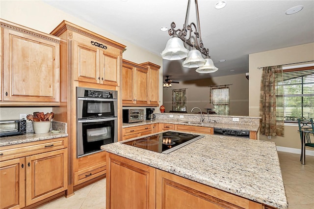 kitchen with sink, black appliances, decorative light fixtures, light tile patterned floors, and light stone counters