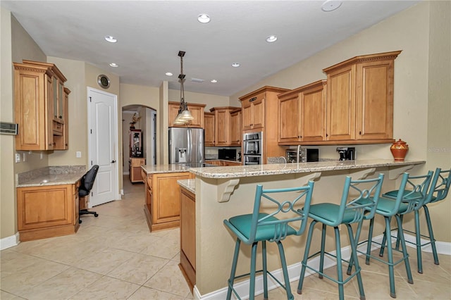 kitchen with kitchen peninsula, a kitchen breakfast bar, stainless steel appliances, pendant lighting, and light stone counters