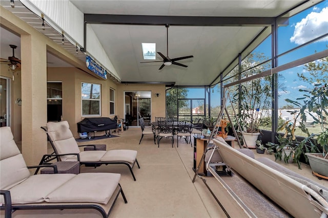 sunroom / solarium with ceiling fan and vaulted ceiling with skylight