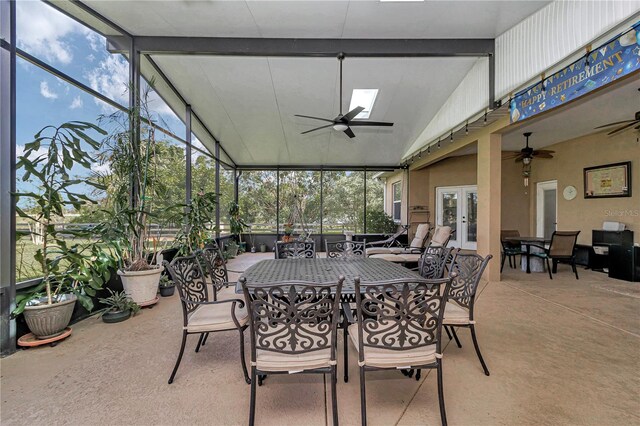 sunroom featuring vaulted ceiling with skylight and ceiling fan