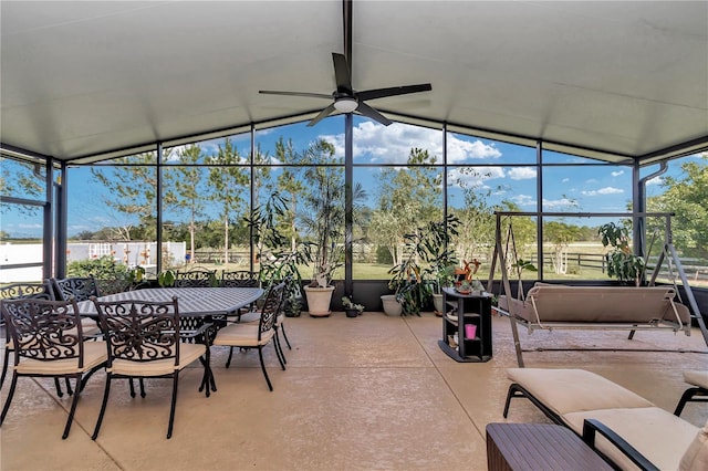 sunroom with ceiling fan and vaulted ceiling