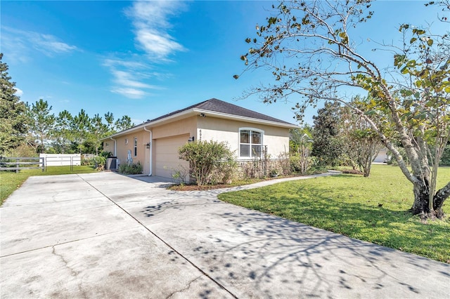 view of front of house featuring cooling unit, a front yard, and a garage