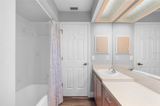 bathroom with hardwood / wood-style flooring, vanity, and shower / tub combo