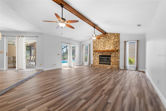 unfurnished living room with vaulted ceiling with beams, hardwood / wood-style floors, and a fireplace