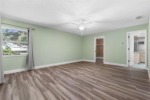 empty room featuring ceiling fan, light hardwood / wood-style floors, and a textured ceiling