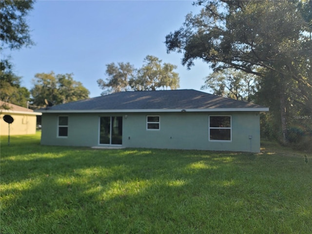 rear view of property featuring a yard