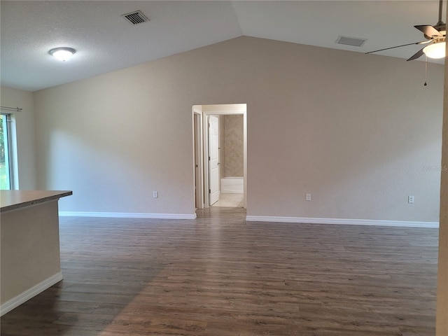 unfurnished room featuring ceiling fan, vaulted ceiling, and dark hardwood / wood-style floors