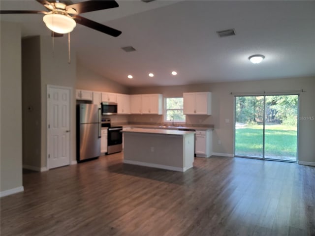 kitchen with vaulted ceiling, stainless steel appliances, dark hardwood / wood-style floors, a center island, and white cabinetry