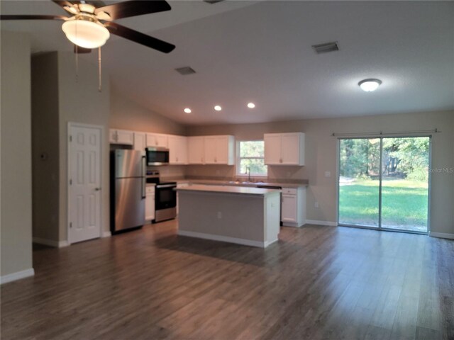 kitchen featuring open floor plan, appliances with stainless steel finishes, white cabinetry, dark wood-style flooring, and recessed lighting
