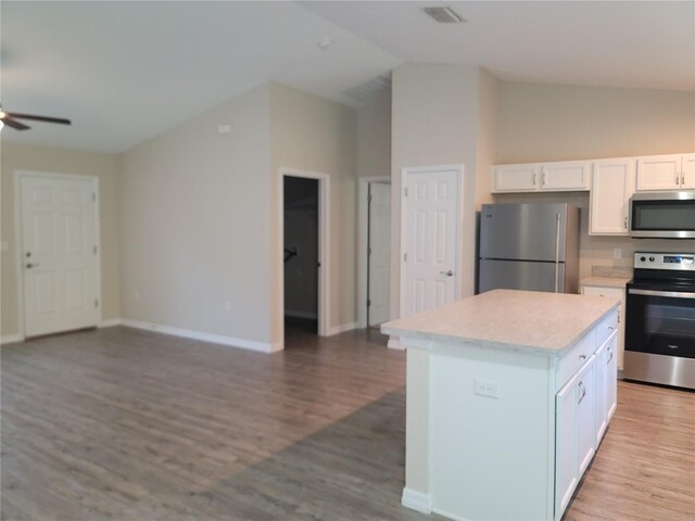 kitchen with white cabinets, stainless steel appliances, visible vents, a ceiling fan, and open floor plan