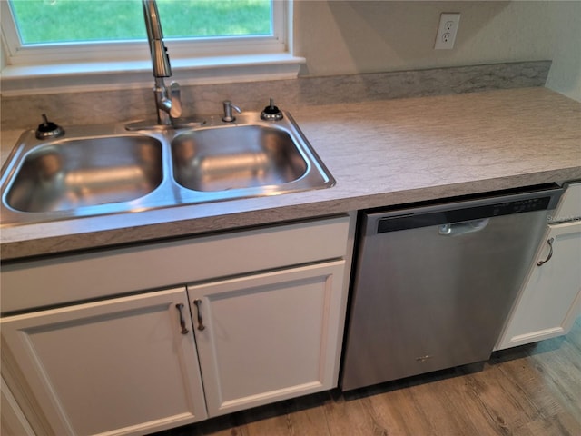 kitchen featuring hardwood / wood-style floors, white cabinets, sink, and dishwasher