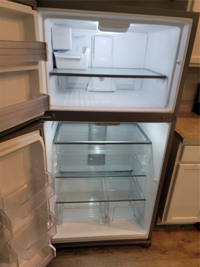 details with white fridge, white cabinetry, and dark hardwood / wood-style flooring