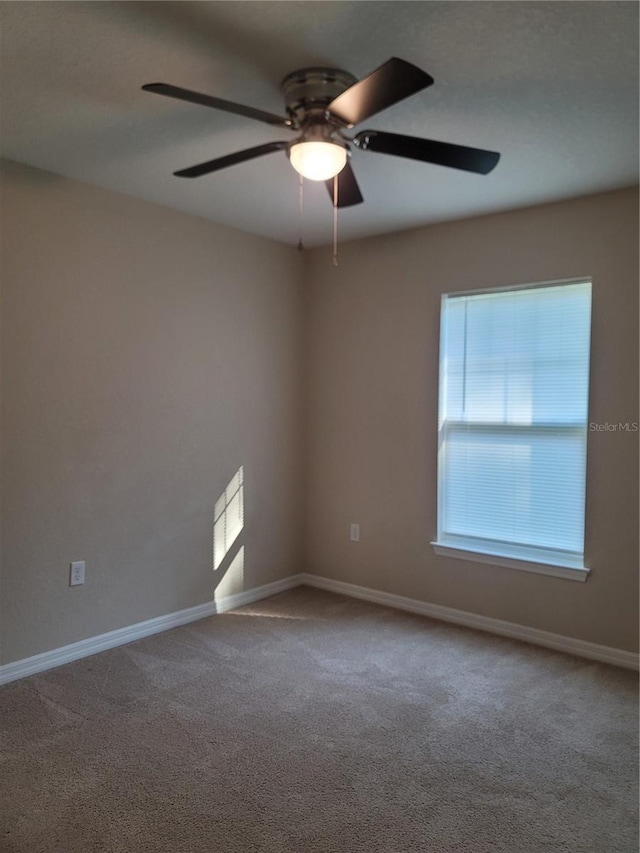 empty room with ceiling fan and carpet