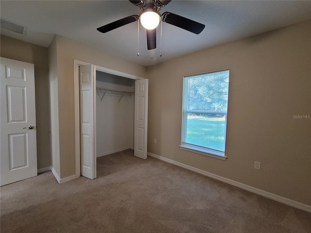 unfurnished bedroom with ceiling fan, a closet, and light carpet