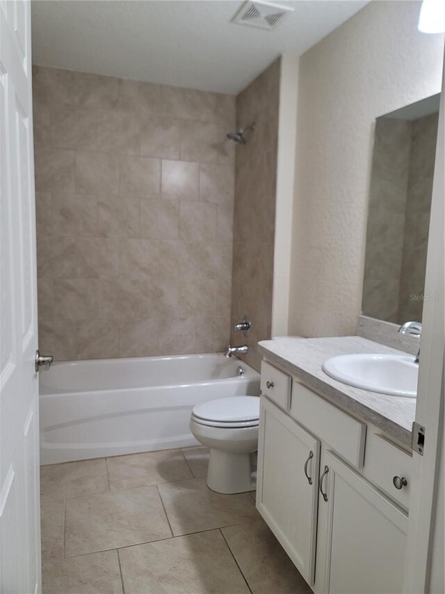 bathroom with tile patterned floors, visible vents, toilet, vanity, and bathtub / shower combination
