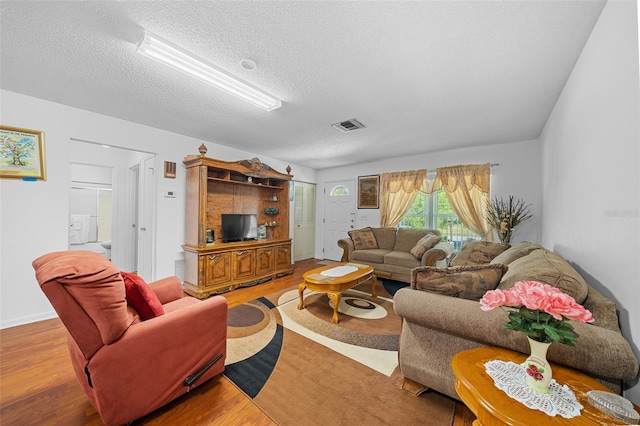 living room with hardwood / wood-style flooring and a textured ceiling