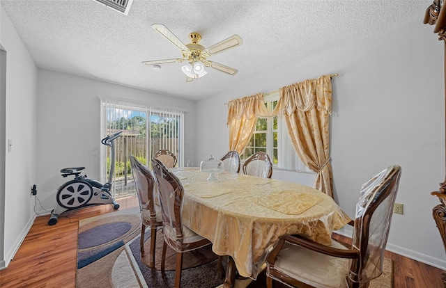 dining area featuring ceiling fan, a textured ceiling, and hardwood / wood-style flooring