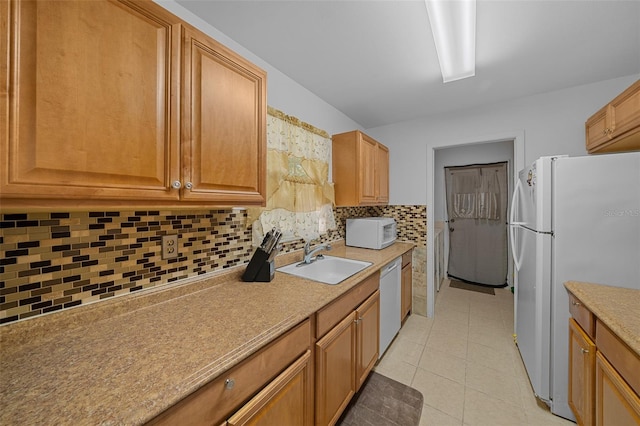 kitchen featuring white appliances, sink, light tile patterned floors, and tasteful backsplash