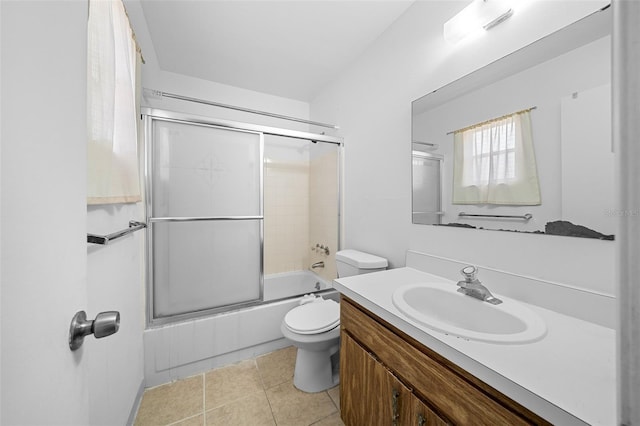 full bathroom featuring tile patterned flooring, vanity, toilet, and combined bath / shower with glass door