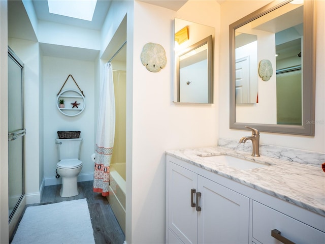 full bathroom featuring vanity, hardwood / wood-style flooring, shower / bath combo, a skylight, and toilet