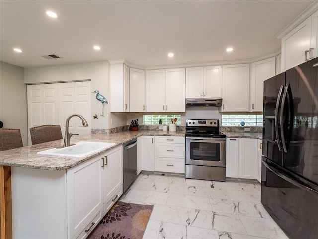 kitchen with white cabinets, sink, kitchen peninsula, appliances with stainless steel finishes, and a breakfast bar