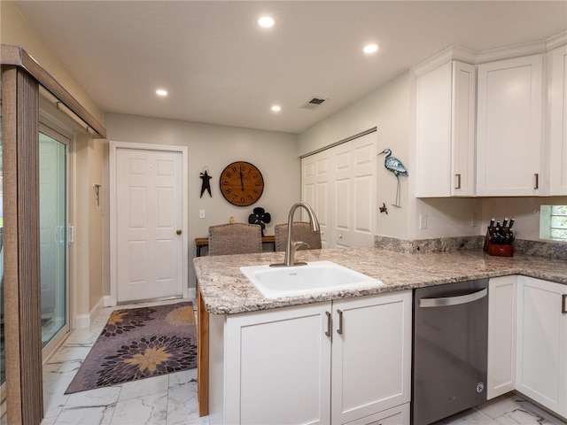 kitchen featuring light stone counters, sink, stainless steel dishwasher, and white cabinetry