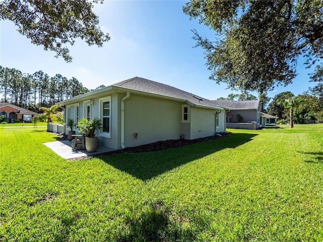 view of side of property with a yard and a patio area