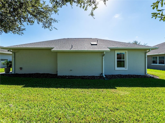 rear view of property featuring a lawn