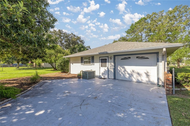 single story home with central AC, a front yard, and a garage