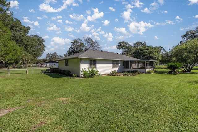 view of home's exterior with a yard and a sunroom