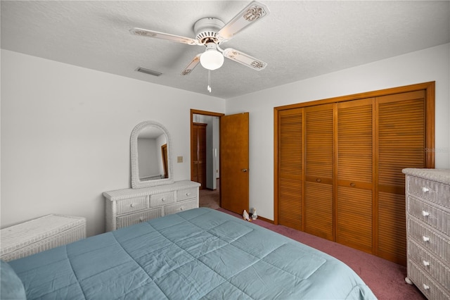 bedroom with a closet, carpet flooring, a textured ceiling, and ceiling fan