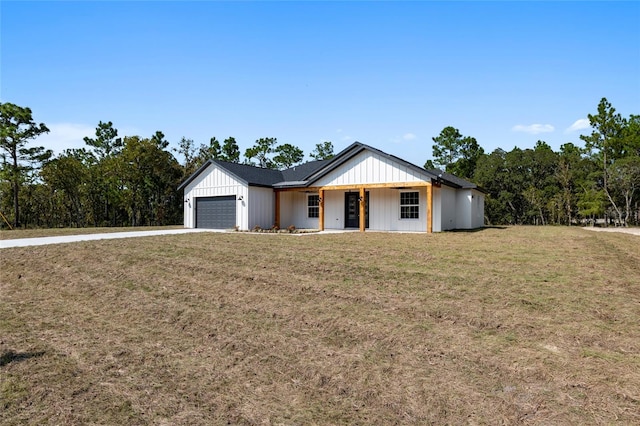 view of front of house featuring a front lawn, covered porch, and a garage