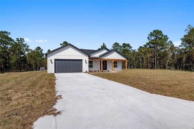 modern inspired farmhouse with covered porch, a front yard, and a garage