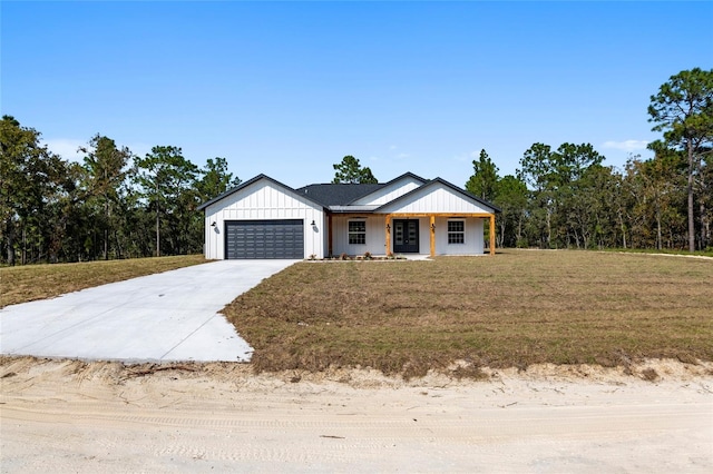 view of front of home with covered porch, a garage, and a front lawn