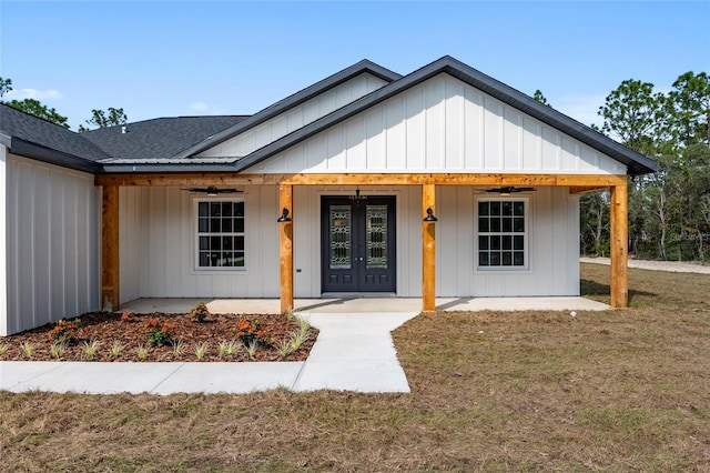 view of front facade with a front yard, french doors, and ceiling fan