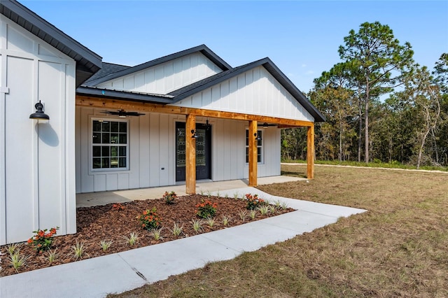 modern inspired farmhouse with ceiling fan, a front lawn, and a porch