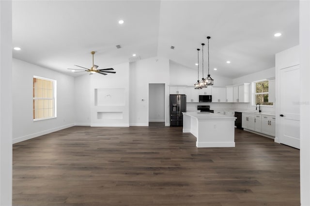 kitchen with a center island, dark hardwood / wood-style flooring, lofted ceiling, white cabinets, and black appliances