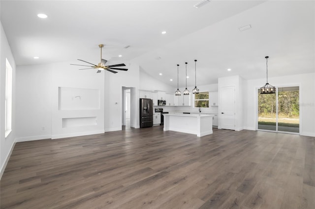 unfurnished living room with a wealth of natural light, dark hardwood / wood-style flooring, and ceiling fan