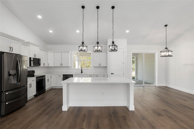 kitchen with white cabinetry, a center island, hanging light fixtures, vaulted ceiling, and black appliances