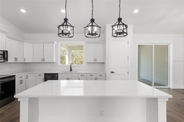 kitchen featuring white cabinets, decorative light fixtures, and light stone countertops