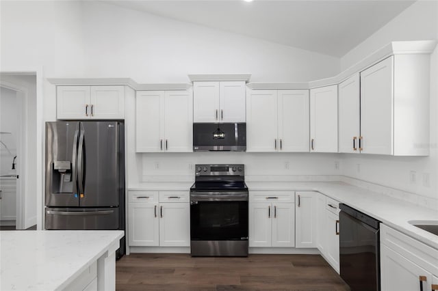 kitchen featuring light stone counters, white cabinetry, appliances with stainless steel finishes, and vaulted ceiling